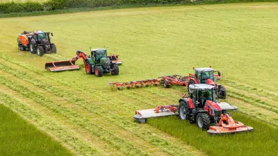 Ein Bild diverser Futtererntemaschinen (Mähwerk, Wender, Schwader und Ballenpresse) aus dem Hause KUHN.