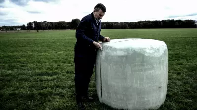 Landwirt öffnet Silageballen mit Messer.