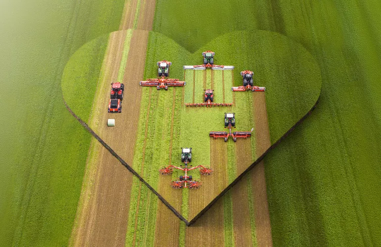 Das Keyvisual der KUHNaktuell. Herbstrasen 2026 - Frühbezug, welches verschiedene Futtererntemaschinen im Einsatz zeigt.