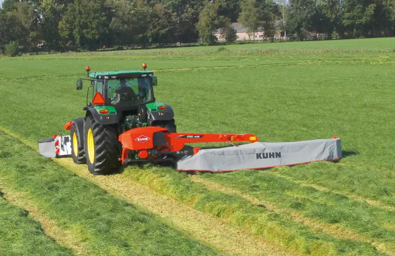 Ein Bild eines Traktors, der mit den KUHN-Mährwerken GMD 3125 F und GMD 4411 ausgestattet ist.
