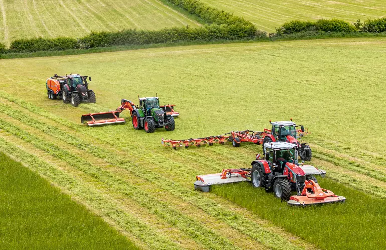 Ein Bild diverser Futtererntemaschinen (Mähwerk, Wender, Schwader und Ballenpresse) aus dem Hause KUHN.