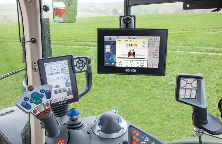 Das Keyvisual für die KUHN Electronics aus der KUHNaktuell. Pflanzenschutz 2025, welches die Innenansicht einer Traktorkabine mit verschiedenen KUHN Electronics-Geräten abbildet