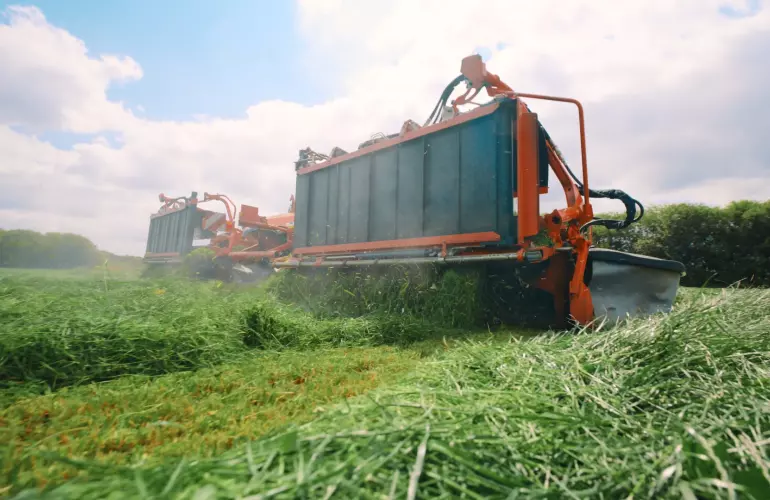 Ein Bild des Schmetterlingsmähwerks FC 9330 RA von KUHN im Einsatz durch das Lohnunternehmen Reuter.