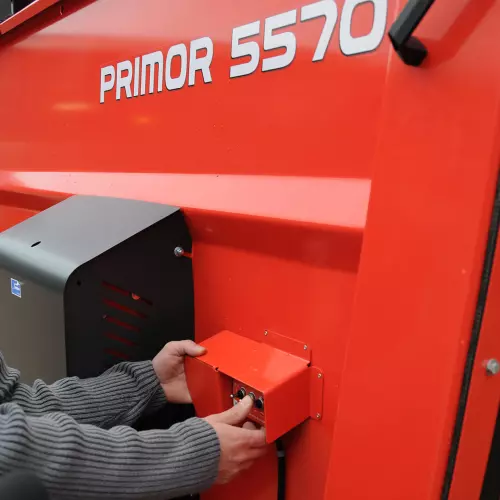 Außenbedienung hinten links für Ladeklappe und Kratzboden des Einstreu- und Verteilgeräts KUHN PRIMOR 4260 M CUT CONTROL mit Häckselfunktion
