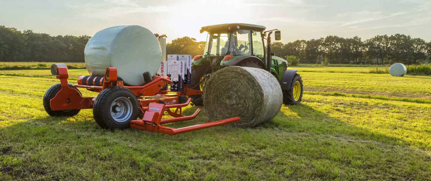 Gezogener Rundballenwickler RW 1610 beim Aufnehmen eines Rundballens und Wickeln eines anderen Ballens.