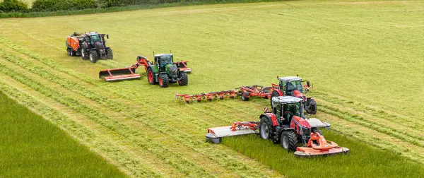 Das Keyvisual für die KUHNaktuell. Futterernte und Pressen 2026, welches den Blick auf mehrere Futtererntemaschinen und Pressen der Firma KUHN zeigt