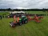 Ein Bild mit einem Traktor mit einem Frontbandschwader und einem Vierkreiselschwader von der KUHN ON TOUR - Futterernte und Pressen 2024.
