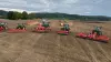 Ein Bild von der KUHN ON TOUR 2023 mit Maschinen, die auf dem Feld in Formation stehen