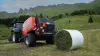 Festkammer-Rundballenpresse KUHN FB 3130 mit Folienbindung beim Pressen von Rundballen in den Bergen